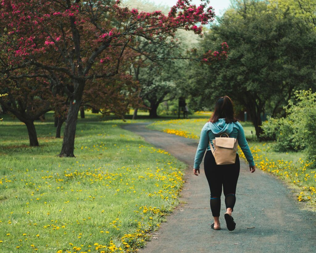 donna in abiti sportivi che cammina nel parco