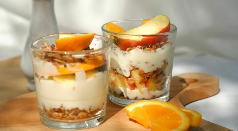 due bicchieri con crema, muesli e frutta
