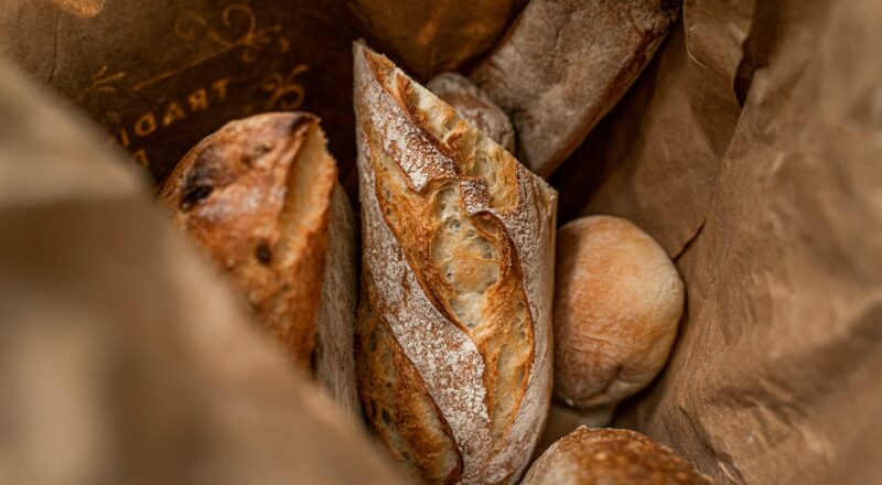 busta di carta marrone con diversi tipi di pane