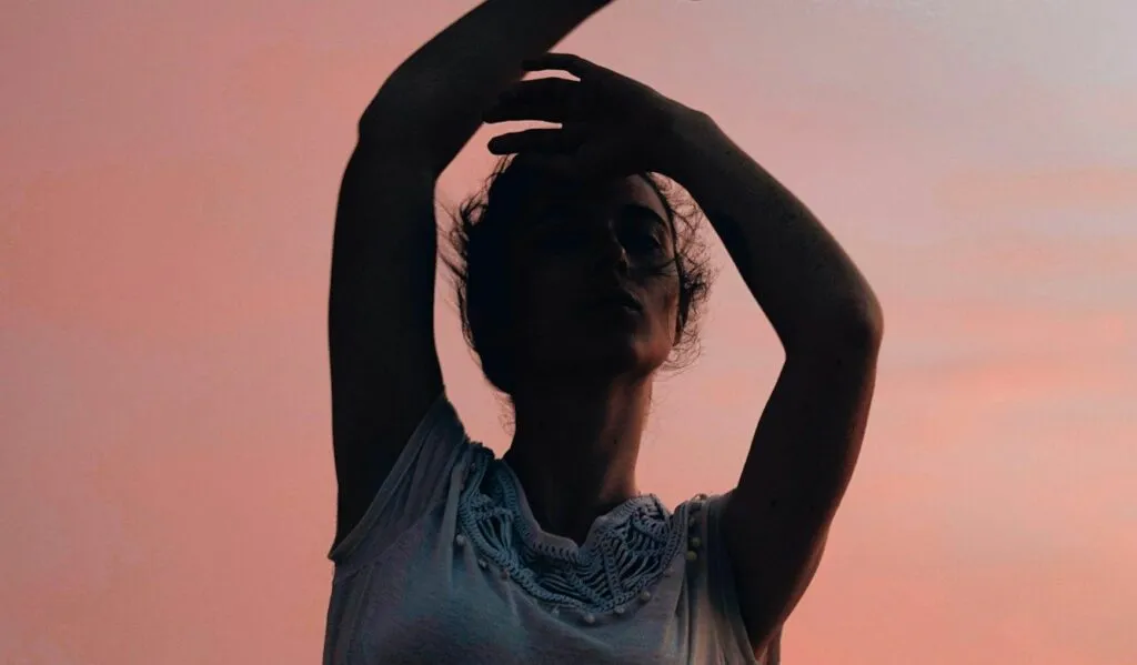 danzatrice al tramonto donna che danza con braccia alzate al tramonto